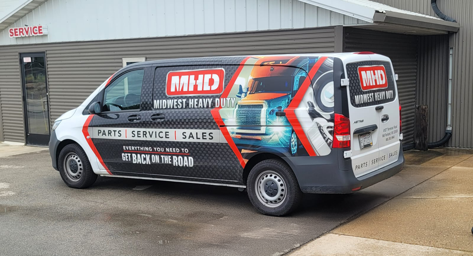 Midwest Heavy Duty Delivery Van with logo on the side of it